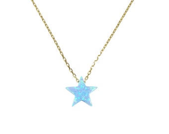 May include: A delicate gold chain necklace featuring a light blue star-shaped pendant. The star has a subtle, iridescent quality, and the chain is a fine, linked design. The necklace is displayed against a white background, highlighting the jewelry's simple elegance.
