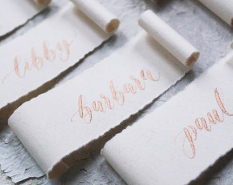 Blush and gold handmade paper scroll place cards with calligraphy