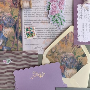 May include: A collection of stationery items, including lilac-colored cards, envelopes, and floral stickers. The image features handwritten notes, a floral stamp, and a spool of ribbon, creating a vintage aesthetic. The text includes the name "Maddy".