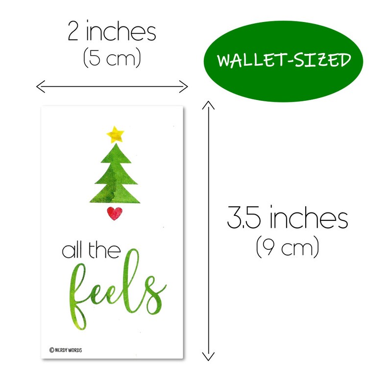May include: A green watercolor Christmas tree with a yellow star on top and a red heart at the base. The text "all the feels" is written in green cursive below the tree. The card is 3.5 inches tall and 2 inches wide.