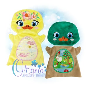 May include: Two plush hand puppets, one yellow with a flower crown and the other green, both with embroidered duck faces. The yellow puppet has a pink and blue egg-shaped pocket with a cloud design, while the green puppet has a brown egg-shaped pocket with a farm scene.