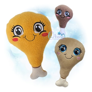 May include: Three plush chicken drumsticks with smiling faces and rosy cheeks. The largest is golden yellow, the middle one is brown, and the smallest is tan. Each has a white bone-shaped base and embroidered details.