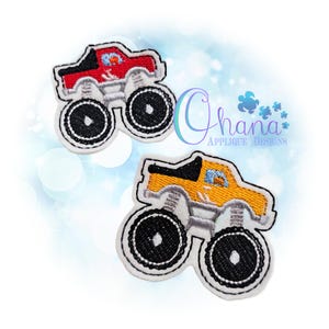 May include: Two embroidered monster truck patches. One is red with a black top, the other is yellow with a black top. Both have large black wheels with white stitching and gray suspension. The patches are on a white background.