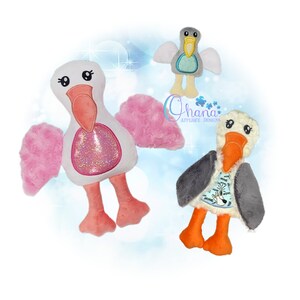 Puede incluir: Tres pájaros de peluche con alas y picos de diferentes colores. El pájaro de la izquierda tiene alas rosas y un pico rosa. El pájaro del medio tiene alas grises y un pico gris. El pájaro de la derecha tiene alas grises y un pico naranja. Los tres pájaros tienen un cuerpo blanco y ojos negros.