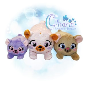 Może przedstawiać: Trzy pluszowe zabawki w kształcie zwierząt z dużymi oczami i uśmiechającymi się twarzami. Zabawki są różowe w białe kropki, fioletowe i brązowe. Wszystkie zabawki leżą i patrzą na kamerę.