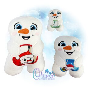 May include: Three white plush snowman toys with embroidered faces. Each snowman is holding a different embroidered image of a snowman in a festive scene. The snowman on the left is holding a snowman wearing a Santa hat. The snowman in the middle is holding a snowman with a green scarf. The snowman on the right is holding a snowman with a blue scarf.