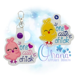 May include: Two keychains with a white background and a pink and yellow chick design. Each keychain features a chick with a heart and the text "one cute chick".