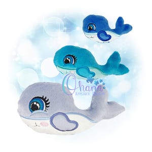 May include: Three plush whale toys in shades of blue and gray. The whales have embroidered details, including eyes, eyelashes, and a heart-shaped design. The toys are soft and cuddly, perfect for children.