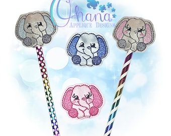 May include: Embroidered elephant pencil toppers in gray, blue, and pink. The toppers are attached to rainbow-striped pencils. The image also includes three standalone elephant applique designs. The text "Ohana Applique Designs" is visible in the image.