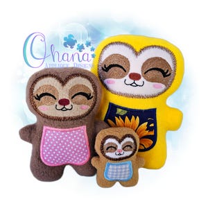 May include: Three plush sloth toys in varying sizes. The sloths have brown and yellow bodies with embroidered faces, closed eyes, and pink cheeks. The largest sloth is yellow and has a sunflower apron. The medium sloth has a pink polka dot apron, and the smallest has a blue gingham apron.
