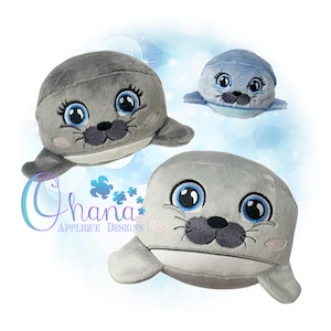 May include: Three plush toy seals with embroidered faces. The seals are gray and blue with white accents. The seals have large eyes and a small nose.
