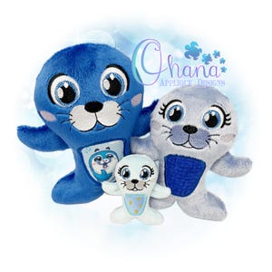 May include: Three plush seal toys in varying sizes. The largest is blue, the middle-sized seal is gray, and the smallest is white. All three have large, expressive eyes, black noses, and embroidered details. The blue seal has a smaller seal graphic on its belly.