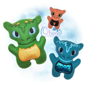 Puede incluir: Tres dragones de peluche en diferentes colores. El dragón verde tiene un pecho dorado, el dragón azul tiene un pecho azul y verde, y el dragón naranja tiene un pecho negro.