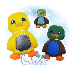 May include: Three plush toy ducks in different sizes. The largest duck is yellow with a black and white belly, the middle duck is green with a blue belly, and the smallest duck is green with a brown belly and a blue belly.