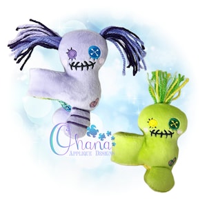 May include: Two handmade plush rag dolls. One doll is purple with blue yarn hair and the other is green with green yarn hair. Both dolls have embroidered faces with button eyes and stitched mouths.