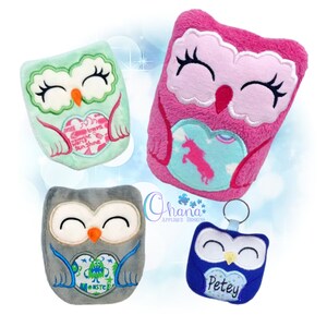 May include: Four plush owl toys with embroidered eyes and beaks. Each owl is holding a heart-shaped patch with different designs. The owls are in various colours, including green, pink, grey, and blue.