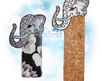 May include: Two elephant-shaped bookmarks, one with a silver and black floral design and the other with a cork background. Both bookmarks feature intricate details and a whimsical elephant design.