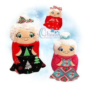 May include: Three plush Christmas ornaments featuring a grandmother figure in a red dress with a white apron and white hair. The ornaments are holding a Christmas tree, a snowman, and a snowflake. The ornaments are all smiling and have a cheerful expression.
