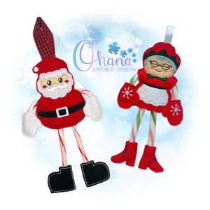 May include: Two Christmas ornaments: Santa Claus and Mrs. Claus. Santa has a red suit, white beard, and black boots. Mrs. Claus wears a red outfit with a white apron and mittens. Both have candy cane arms and legs. The ornaments are from Ohana Applique Designs.