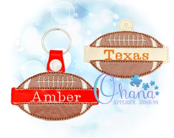 Puede incluir: Dos llaveros con forma de balón de fútbol. Uno tiene una pancarta roja con el nombre "Amber" bordado. El otro tiene una pancarta beige con la palabra "Texas" bordada. Ambos son marrones con costuras blancas.