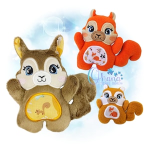 May include: Three plush squirrel toys in shades of brown and orange. Each has embroidered details, including large eyes and a small belly patch with a woodland scene. The toys are designed with a cartoonish aesthetic.