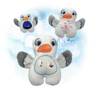 Puede incluir: Tres juguetes de peluche de gaviota con cuerpos blancos, alas grises y picos naranjas. Cada gaviota tiene un diseño diferente en su vientre, incluyendo peces, un pulpo y dos gaviotas. Sobre un fondo azul claro.