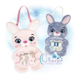 May include: Two plush bunny bags, one pink and one blue, with embroidered faces and handles. The pink bunny has a floral design on its belly, while the blue bunny holds a tooth-shaped design. The bags are designed with a cartoonish aesthetic.