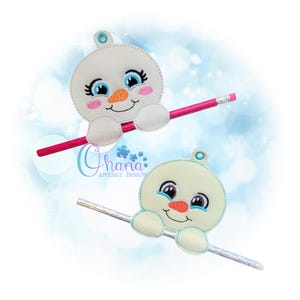 以下が含まれることがあります： 笑顔と青い目をした白い雪だるまの鉛筆トッパーが2つ。上の雪だるまはピンクの鼻と頬をしていますが、下の雪だるまはオレンジの鼻をしています。両方の雪だるまは鉛筆を持っています。