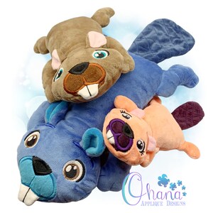 May include: Three plush beaver toys stacked on top of each other. The top beaver is brown, the middle beaver is blue, and the bottom beaver is peach. All three beavers have embroidered eyes, noses, and mouths.
