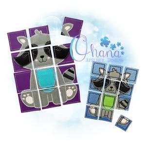 May include: Two raccoon-themed puzzle toys. One is assembled, the other is partially assembled. The puzzles are made of square pieces in shades of gray, purple, and blue. The assembled raccoon has a turquoise belly and a striped tail. The text "Ohana Applique Designs" is visible.
