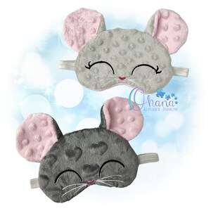 Peut inclure: Deux masques de sommeil en forme de souris gris et rose avec des yeux et des moustaches brodés. Les masques sont en tissu gris avec un motif subtil et des oreilles roses avec une surface texturée.