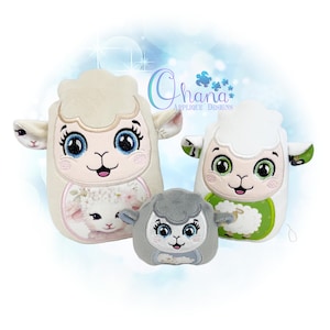 May include: Three plush sheep toys in varying sizes. The largest is off-white with a lamb graphic, the middle one is white with a green bib, and the smallest is gray. All have embroidered faces with blue eyes and pink accents.