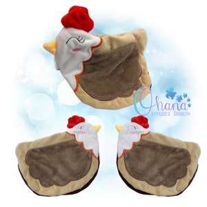 May include: A plush chicken-shaped pillow with a red comb, white face, and brown body. The pillow has a smiling face with closed eyes and a yellow beak. The image includes three pillows, one in the air and two on the ground.