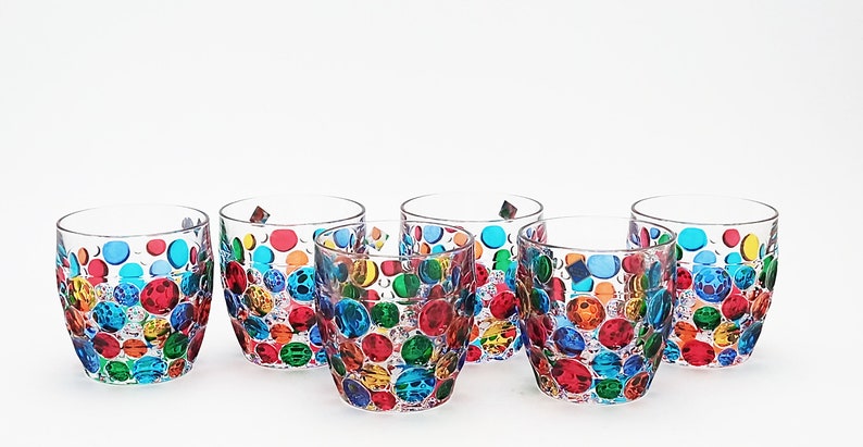 May include: Set of six clear glass tumblers with a colorful polka dot design. Each tumbler features a unique pattern of red, orange, yellow, green, blue, and purple dots.