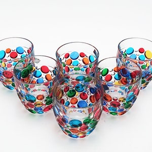 May include: Set of six clear glass tumblers with colorful polka dots. Each tumbler has a different pattern of red, orange, yellow, green, blue, and purple polka dots.