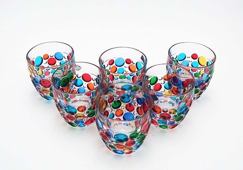 May include: Set of six clear glass tumblers with colorful polka dots. Each tumbler has a different pattern of red, orange, yellow, green, blue, and purple polka dots.