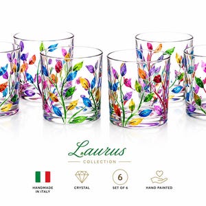Può includere: Un set di sei bicchieri in cristallo trasparente della collezione Laurus, ciascuno con disegni di foglie dipinti a mano in tonalità rosso, blu, giallo e viola. I bicchieri sono disposti su due file e includono etichette per handmade in Italy, crystal, set of 6 e hand painted.