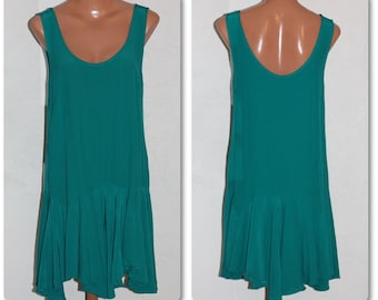 May include: A teal sleeveless dress with a ruffled hemline. The dress is made of a smooth, silky fabric.