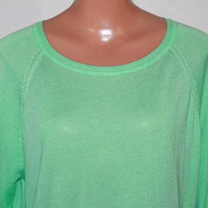 以下が含まれることがあります： 丸首のライトグリーンのロングスリーブセーターです。