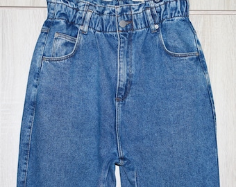 May include: A pair of blue denim jeans with a high waist and a gathered elastic waistband.