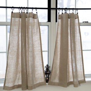 Puede incluir: Dos pares de cortinas de caf&eacute; de lino beige colgadas de una barra de cortina negra. Las cortinas est&aacute;n fruncidas en la parte superior y tienen un estilo sencillo y casual.
