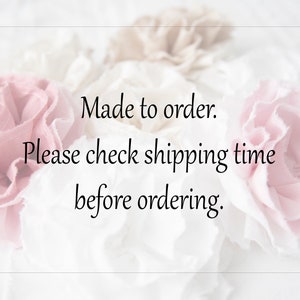 May include: A close-up of a text overlay on a white background with pink and white fabric flowers. The text reads "Made to order. Please check shipping time before ordering."