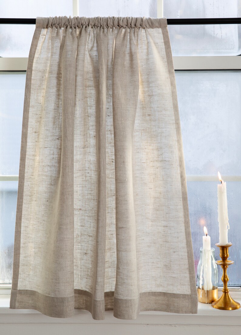 May include: A natural linen valance with a gathered top and a simple, straight bottom edge. The valance is hanging in a window with two candles on the windowsill.