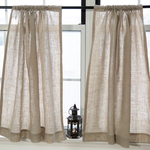 Puede incluir: Dos cortinas de caf&eacute; de lino beige con un ribete superior fruncido y un dobladillo sencillo. Las cortinas est&aacute;n colgadas en una ventana con una barra negra.