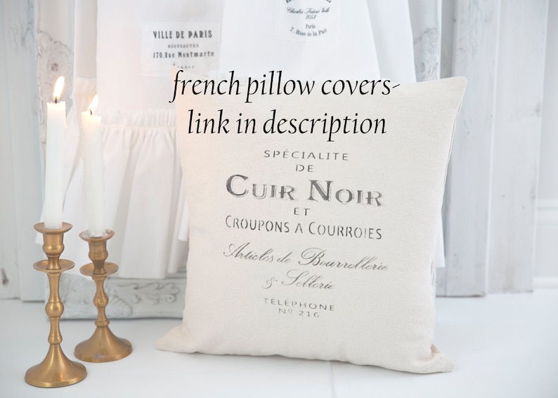 May include: White pillow cover with black text that reads "Specialite de Cuir Noir et Croupons a Courroies Articles de Bourrelterie Sellerie Telephone N&deg; 216".
