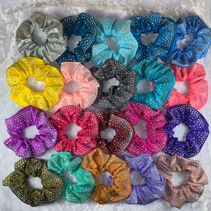 May include: A collection of 20 colorful hair scrunchies with rhinestones. The scrunchies are made of soft fabric and have a variety of colors, including pink, blue, purple, green, and brown.