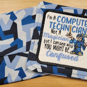 May include: A blue and black fabric coaster with a white embroidered patch that reads "I'm a Computer Technician Not a Magician but I can see why you might be Confused".