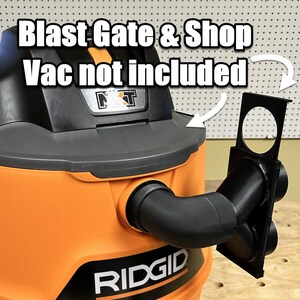 Puede incluir: Aspiradora de taller naranja y negra con una compuerta de explosi&oacute;n negra y un adaptador para aspiradora de taller. El texto "RIDGID" est&aacute; impreso en el lateral de la aspiradora. El texto "Blast Gate & Shop Vac not included" est&aacute; escrito en blanco sobre fondo negro.