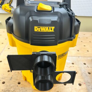 May include: A yellow and black DEWALT wet/dry vacuum with a black handle and a yellow button. The vacuum has a black attachment with two circular openings and a circular hole. The DEWALT logo is prominently displayed on the front.