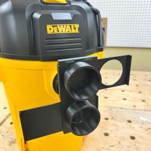 May include: A yellow and black DEWALT wet/dry vacuum with a black 3D-printed attachment. The attachment has two circular openings and a larger circular opening. The DEWALT logo is in yellow.